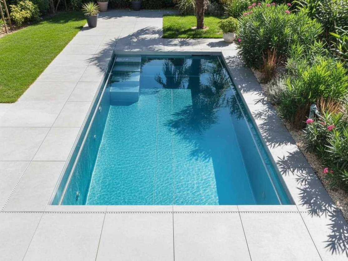 Moderner Gartenpool mit eingelassener Treppe, Terrassenplatten und Bepflanzung in Ingolstadt